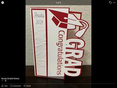 a red and white graduation card with the words congratulations on it, sitting on top of a table