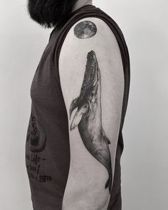 a man with a half sleeve tattoo on his arm and the image of a dolphin