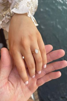 a woman's hand with a diamond ring on top of her left hand next to a man's hand