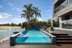 an empty swimming pool in front of a house with stairs leading up to the water