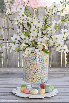 a glass vase filled with white flowers and candy