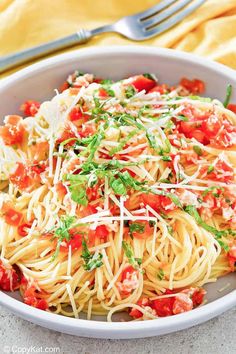 a white bowl filled with pasta and garnished with parmesan cheese