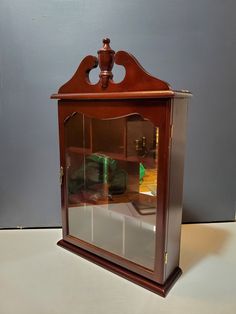 an old fashioned wooden clock with glass front