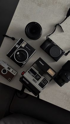 an assortment of cameras sitting on top of a table