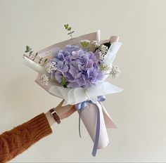 a person holding a bouquet of flowers in their hand