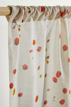 the curtain is closed and ready to be hung in front of a window with an orange flowered design on it