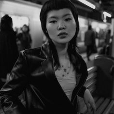 black and white photograph of a woman in a train station with her hand on her hip