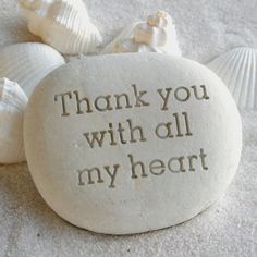 a rock that says thank you with all my heart surrounded by sea shells and seashells