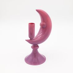 a pink candle holder sitting on top of a white table