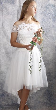 a woman in a white dress holding flowers