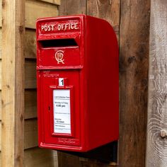 a red post box mounted to the side of a wooden wall