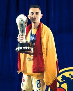 a man holding a soccer trophy in his hands