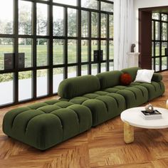 a living room filled with lots of furniture next to large glass windows on the wall