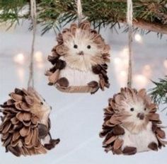 three ornaments hanging from a tree with pine cones on it's sides and two hedgehogs in the middle