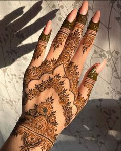 a woman's hand with henna tattoos on it