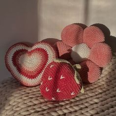 two strawberries are sitting next to each other on a woven table cloth with hearts in the center