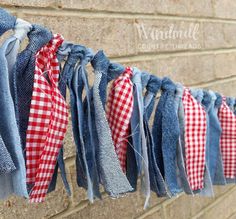 several pieces of fabric hanging on a brick wall