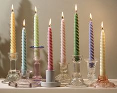 there are many different colored candles on the table