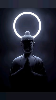 a buddha statue sitting in the middle of a dark room with a halo around it's head