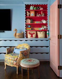 a living room with blue walls and shelves filled with colorful items on top of them