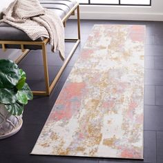 a living room area with a rug, chair and potted plant