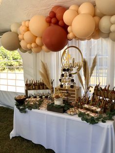 a table topped with lots of desserts and balloons