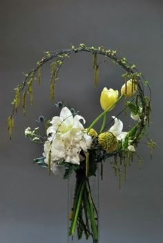 a vase filled with white flowers and greenery