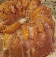 a close up of a bundt cake with icing and peaches on it