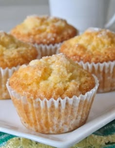 three muffins on a white plate with a cup of coffee in the background