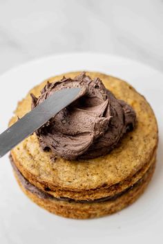 a chocolate frosted cookie on top of each other with a knife stuck in it