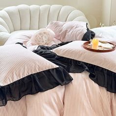 a bed with pink and white comforters on top of it