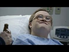 a man laying in a hospital bed holding a beer and looking up at the sky