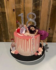 a birthday cake with a doll on top and the number 31 spelled out in pink icing