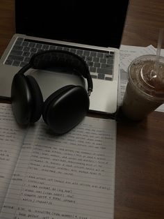 an open laptop computer sitting on top of a desk next to a cup of coffee