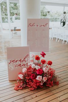 the table numbers were placed on top of each other and decorated with red, white and pink flowers