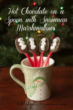 hot chocolate on a spoon with snowman marshmallows in a coffee cup