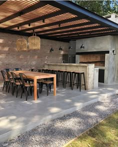 an outdoor kitchen and dining area is shown in this backyard setting with concrete flooring