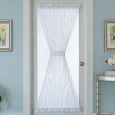 a white door with sheer curtains in a blue room