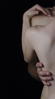 a nude woman with her hands on her chest