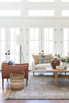 a living room filled with lots of furniture and decor on top of a hard wood floor