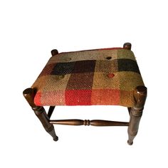 a wooden bench with a plaid seat cushion on it's back legs and feet