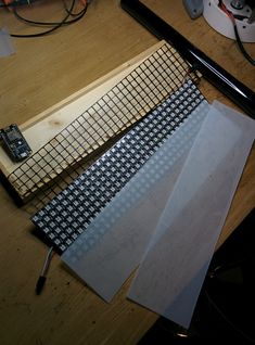 three pieces of paper sitting on top of a wooden table