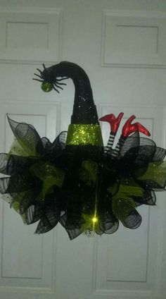 a door hanger decorated with black mesh and green tulle, featuring an image of a witch's hat