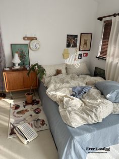 an unmade bed sitting in a bedroom next to a window