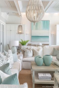 a living room filled with furniture and a chandelier hanging over the top of it