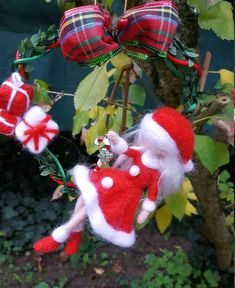 two red and white christmas decorations hanging from a tree