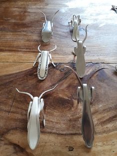 three metal bugs sitting on top of a wooden table