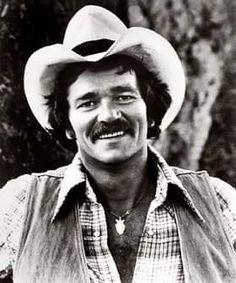 a black and white photo of a man wearing a cowboy hat