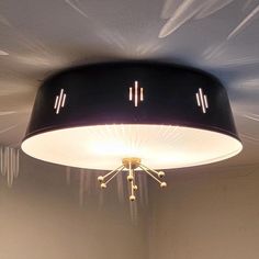 a ceiling light that is hanging from the ceiling in a room with white walls and flooring