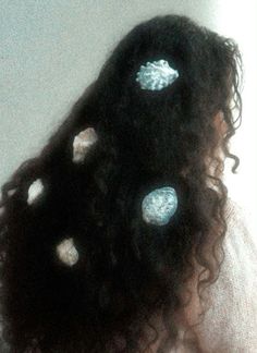 the back of a woman's head with white dots on it and black hair